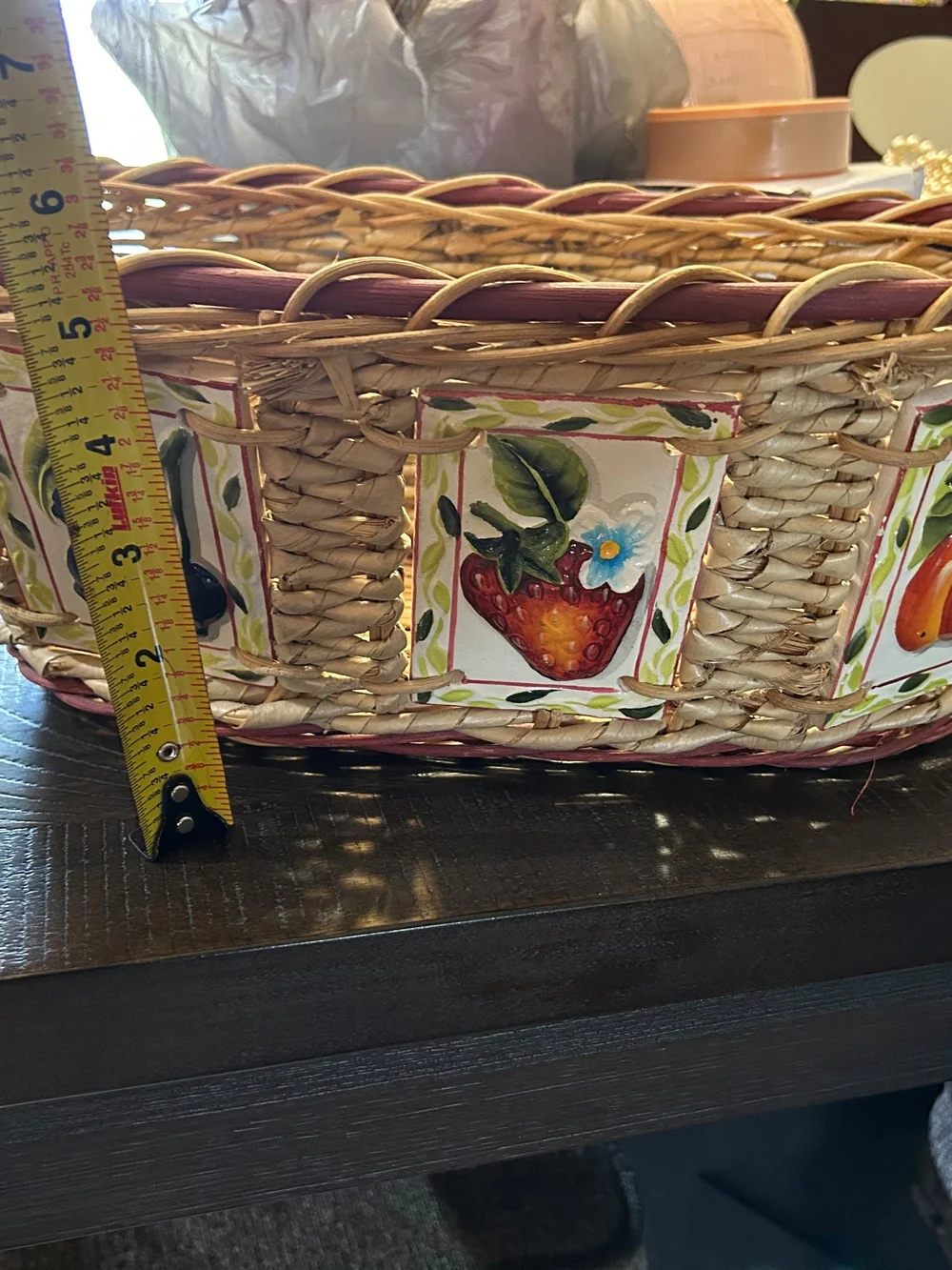 vintage woven wicker basket features hand-painted ceramic fruit tiles.